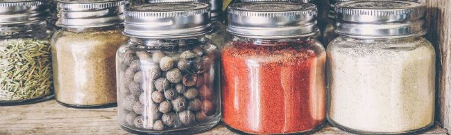 Gewürze für gesunde Ernährung: Kräuter, Gewürzkörner, Paprikapulver und mehr im Glas.