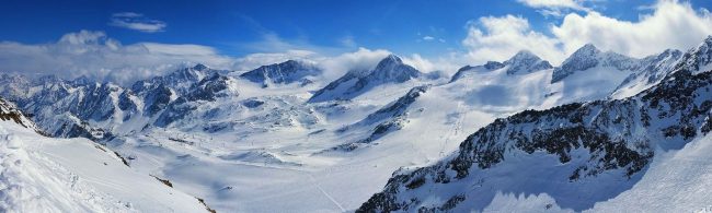 Schneebedeckte Berggipfel und Skipisten, ideal für aktiven Wintersport und Fitness.