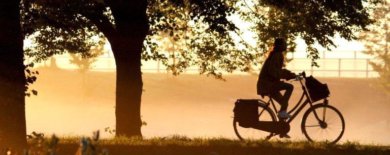 Frau radelt bei Sonnenaufgang für Fitness und Wohlbefinden.