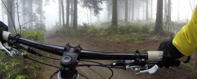 Gelbes Shirt auf einem Fahrrad im nebligen Wald: Fitness-Abenteuer.