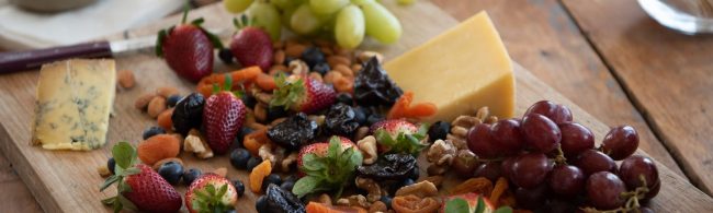 Fitness-Snack-Brett mit Käse, Beeren, Nüssen und Trockenfrüchten.