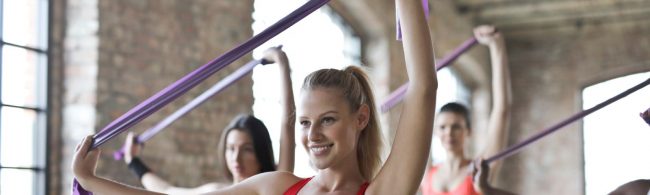 Frauen mit Widerstandsbändern im Fitnessstudio: Übungen für Kraft und Ausdauer.