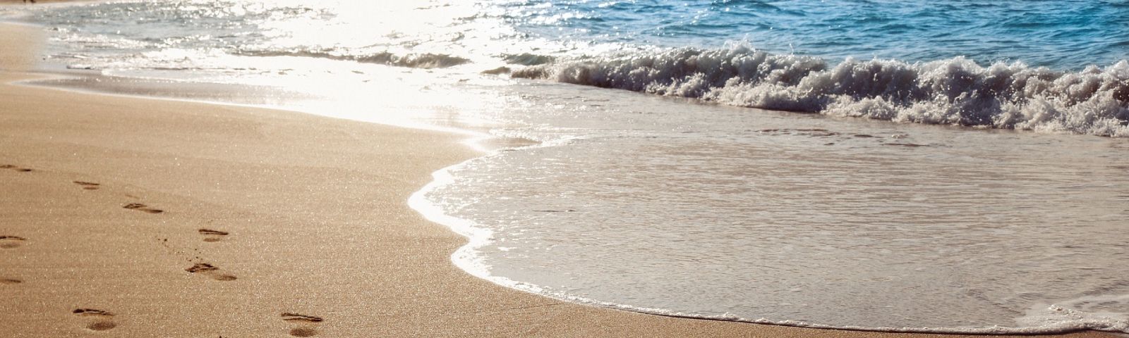 BF-zand-1600×480 Fußspuren im Sand: ein Symbol für Fitnessziele und gesunde Ernährung.