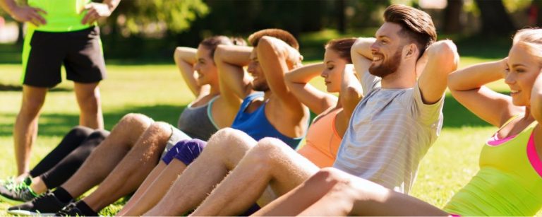 Fitnessgruppe trainiert im Park mit Ernährungsfirma für gesunde Ernährung.