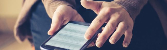 Person hält ein Smartphone mit Fitness-App in den Händen.