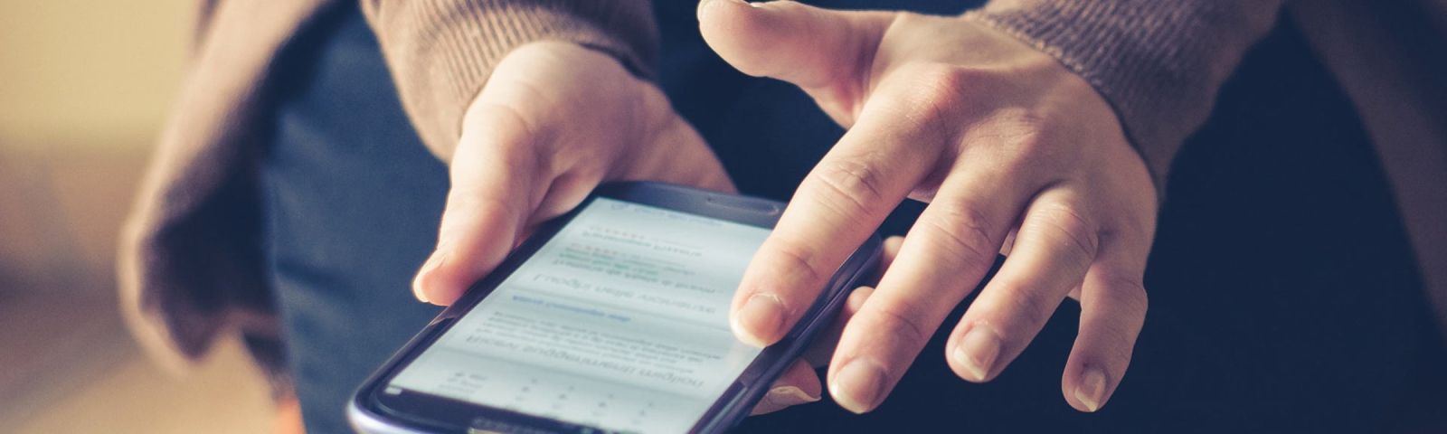 Person hält ein Smartphone mit Fitness-App in den Händen.