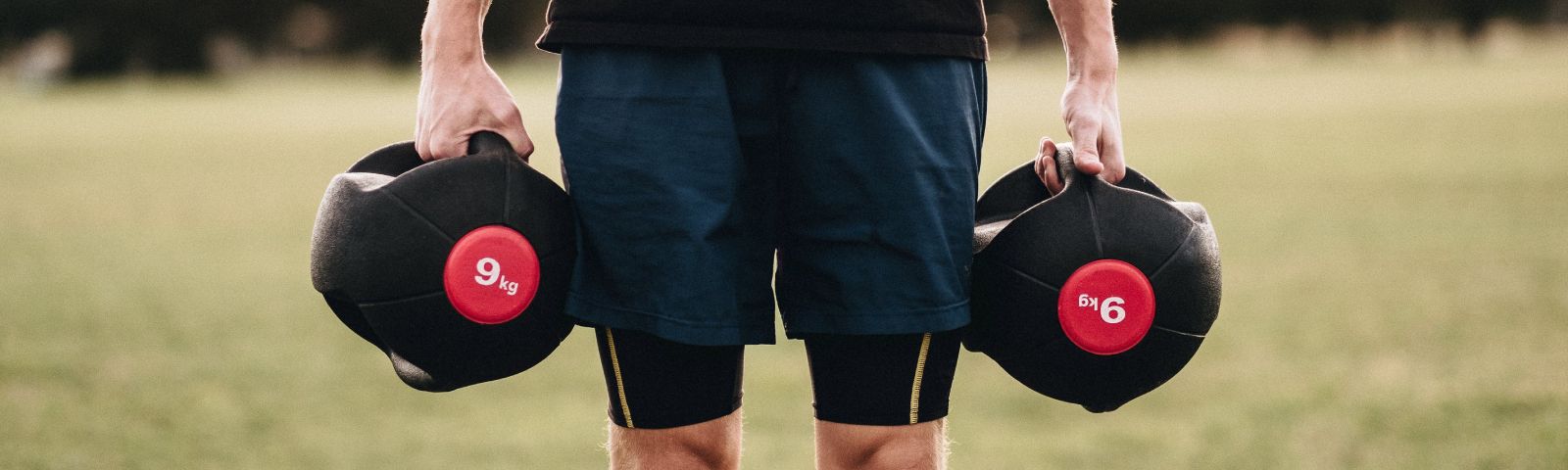 Ein Mann mit Trainingsgewichten im Freien. Fitness und Ernährung im Fokus.