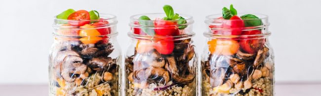 mealpreppen-1600×480 Drei gesunde Mahlzeiten im Glas: Quinoa, Pilze, Tomaten und Basilikum – perfekt für Fitness-Fans.