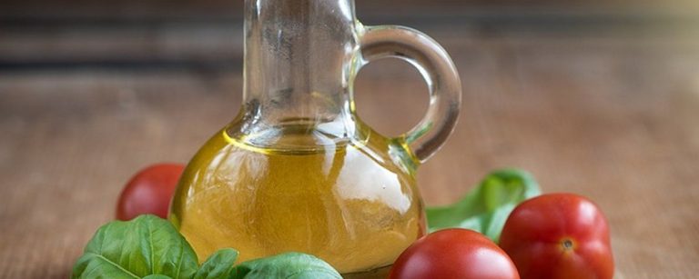 Olivenöl-Flasche mit Tomaten und Basilikum für gesunde Ernährung und Fitness.