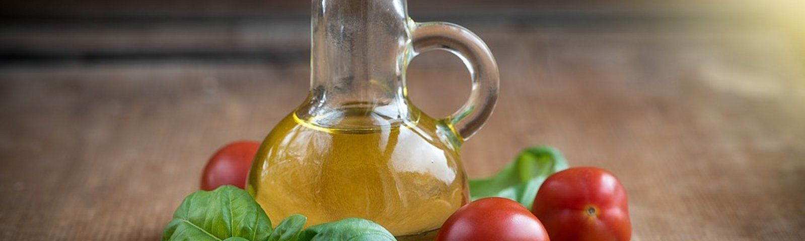 oil-1383546-960-720groot Olivenöl-Flasche mit Tomaten und Basilikum für gesunde Ernährung und Fitness.