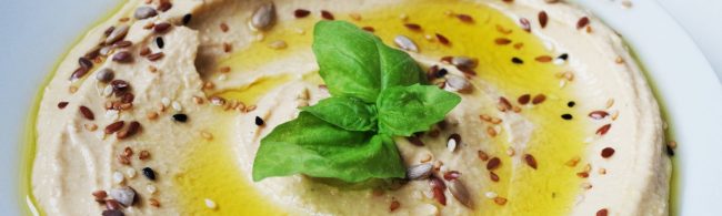 Köstliches Hummus mit Samen und Basilikum, perfekt für eine gesunde Ernährung.