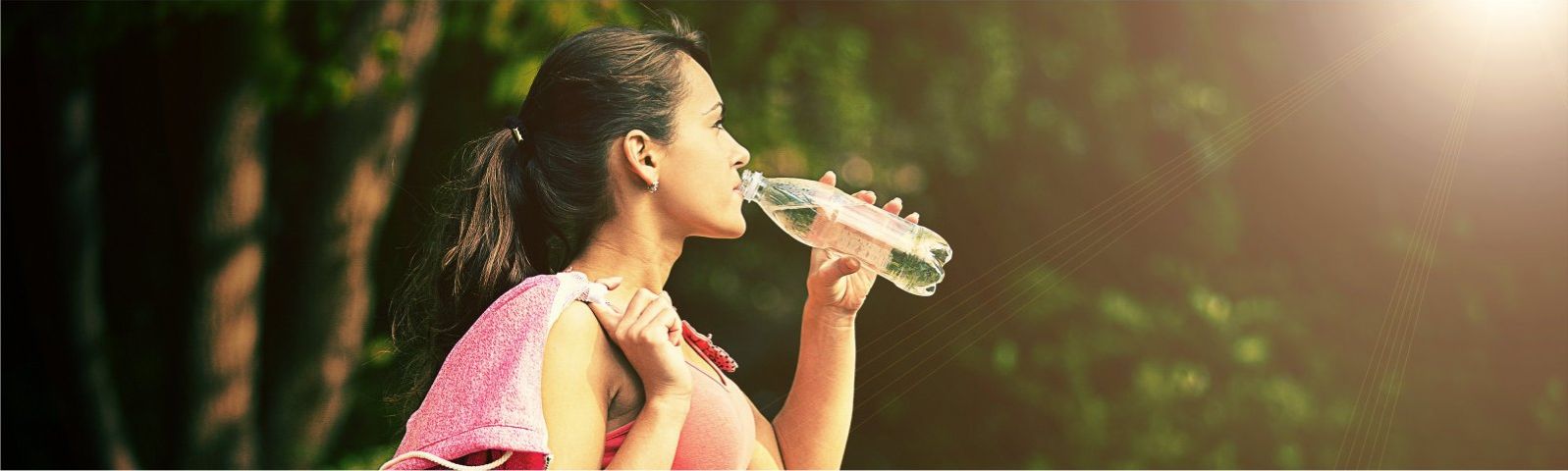 stofwisseling-groot Junge Frau trinkt nach dem Sport Wasser in der Natur.