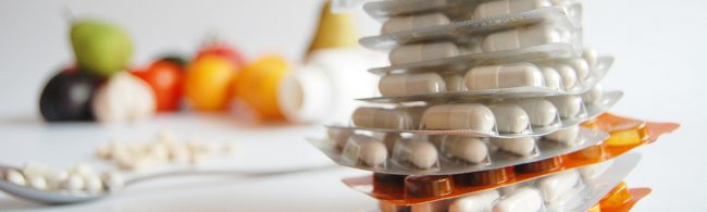 Pillen-Packungen und Früchte, ideal für Fitness-Ernährung, Nahrungsergänzungsmittel.