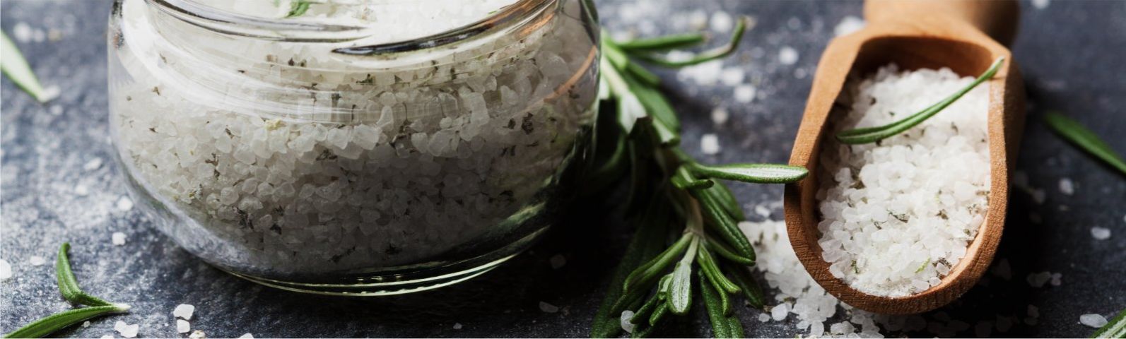 zout-2 Grobes Salz mit Rosmarin in einem Glas und Holzlöffel für gesunde Ernährung.