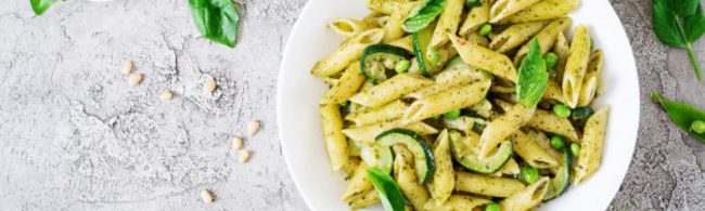 Gesunde Penne-Pasta mit Zucchini und Erbsen in Pesto, ein proteinreiches Gericht für Sportler.