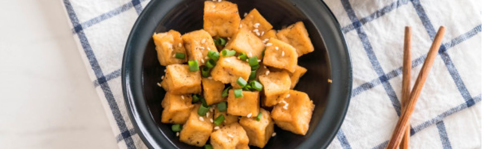 Gebratene Tofuwürfel mit Frühlingszwiebeln und Sesam. Proteinreich, vegan, glutenfrei.