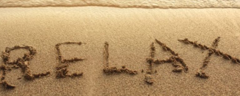 Wort "RELAX" in Sand geschrieben am Strand - Fitness und gesunde Ernährung für dein Wohlbefinden.