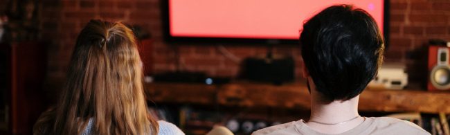 Mann und Frau schauen fern, gesunde Ernährung und Fitness im Fokus.