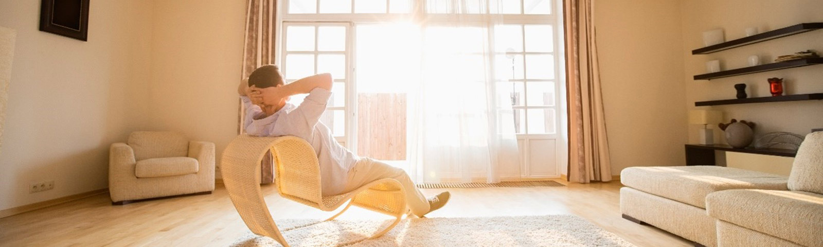 Mann entspannt in einem modernen Wohnzimmer, umgeben von hellem Licht.