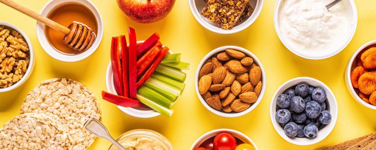 Gesunde Snacks: Nüsse, Obst, Joghurt und Gemüse für ein energiegeladenes Workout.