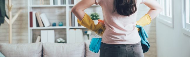 Frau mit Reinigungsmitteln bereit für den Frühjahrsputz im Fitnessstudio.