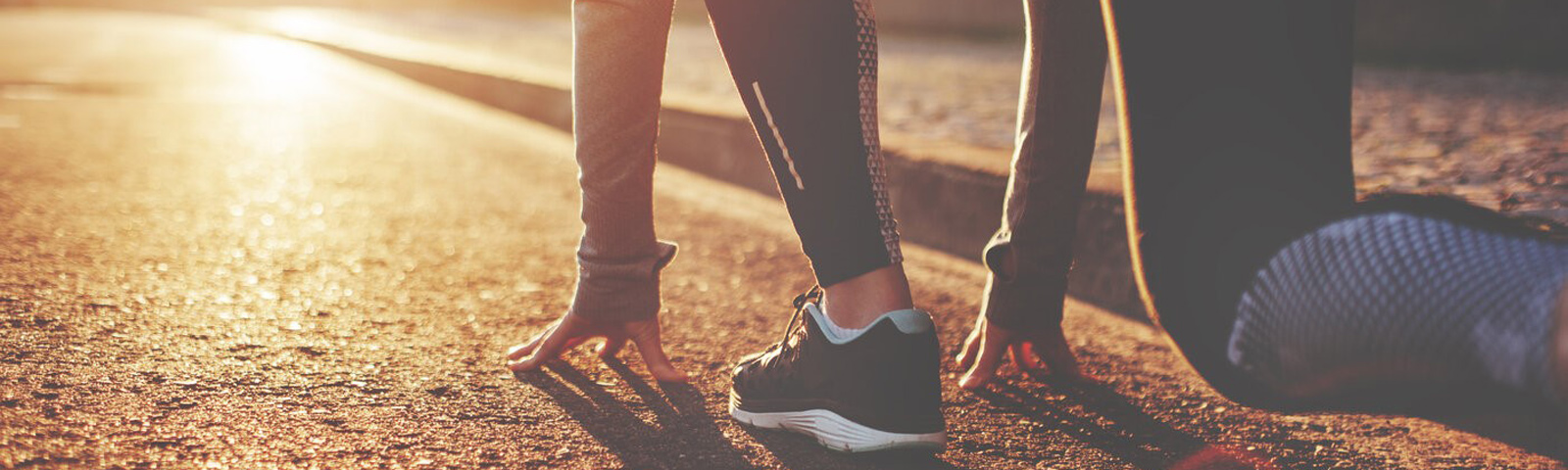bewegen-op-een-lege-maag Läuferin in Startposition im Sonnenuntergang für Fitness und Ernährung.