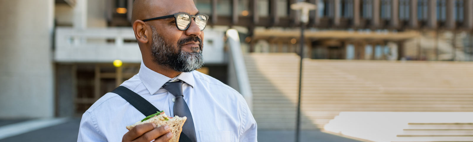 Mann mit Bart isst Sandwich, gesunde Ernährung für Fitness.