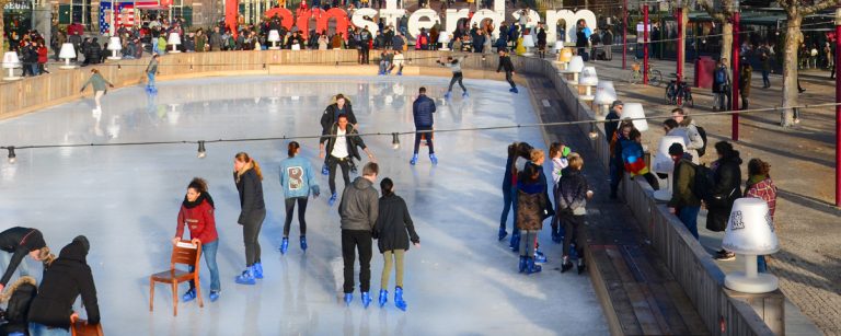 Ice skater gliding in low stance on an outdoor winter rink, showing strong leg drive and stable core with frosty breath in the air.