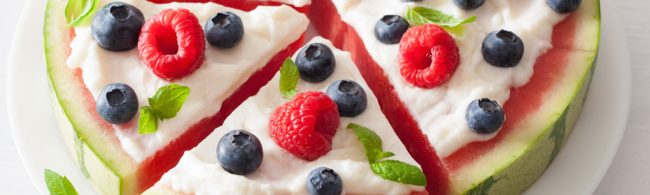 Watermelon slice topped with Greek yogurt, raspberries, blueberries and mint