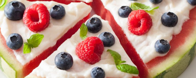 Watermelon slice topped with Greek yogurt, raspberries, blueberries and mint