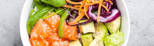 Homemade poke bowl with sushi rice, salmon or tofu, avocado, cucumber and edamame