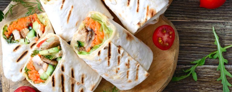 Whole grain wraps filled with hummus, spring vegetables and egg, ready to eat